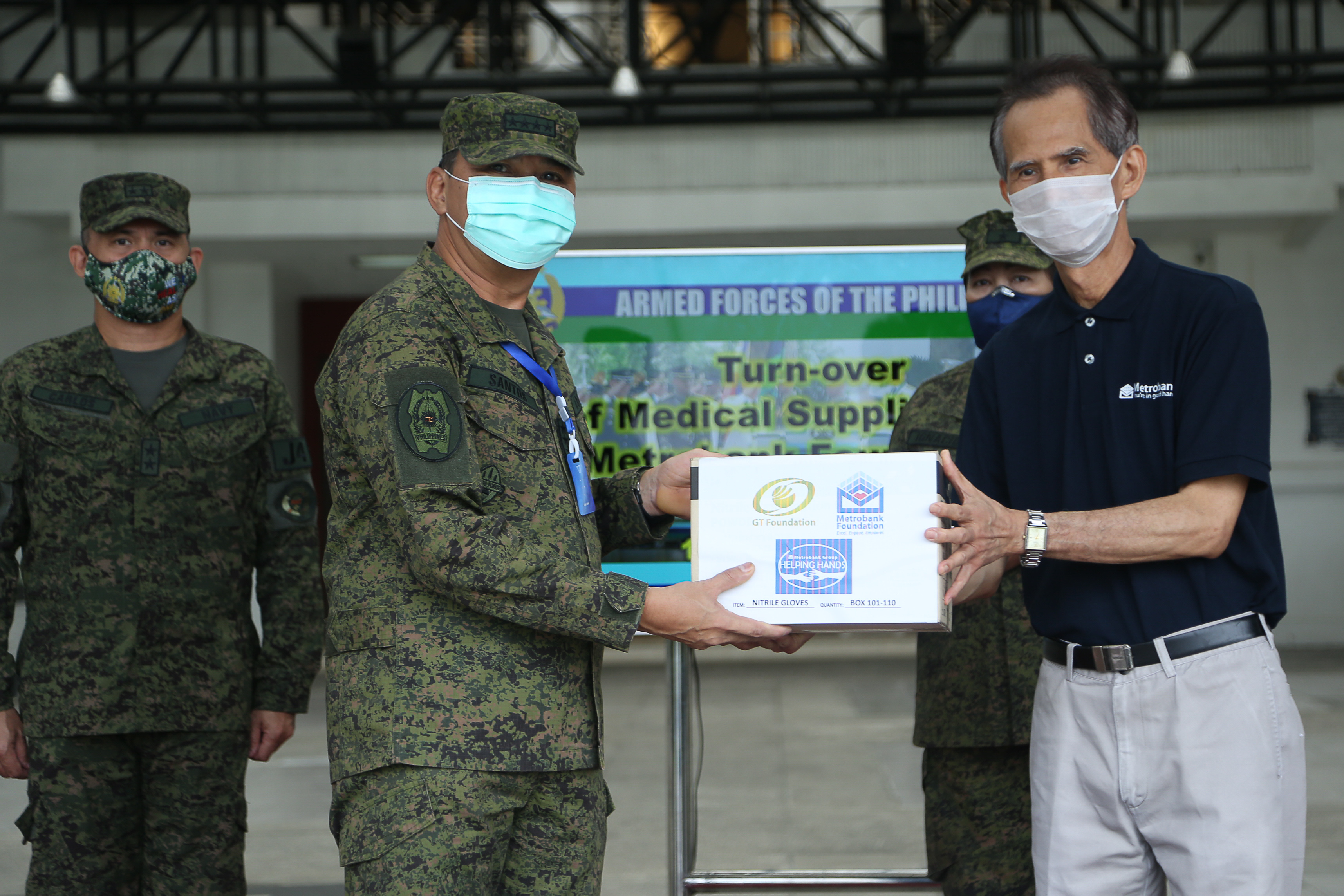 Metrobank Foundation executive director Nicanor Torres, Jr. turns over 54,600 pairs of gloves and 5,000 N95 masks to Armed Forces of the Philippines (AFP) through AFP Chief of Staff Gen. Felimon Santos.